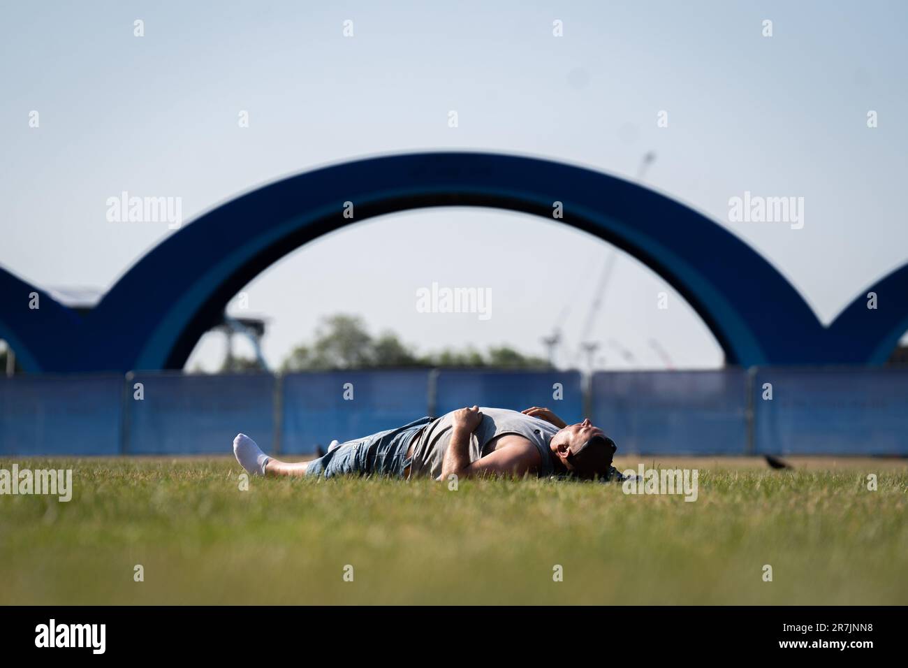 A man sunbathes in Hyde Park, London. The hot weather is forecast to remain across the UK into next week and the Met Office has forecast temperatures in the high 20s, with some areas reaching into the 30s. Picture date: Friday June 16, 2023. Stock Photo