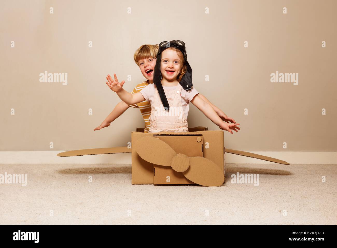 Boy play cardboard plane, wears hat, glasses pretends to fly Stock Photo Alamy