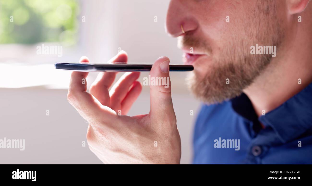 Young Man Using Voice Recognition Function On Mobile Phone Stock Photo