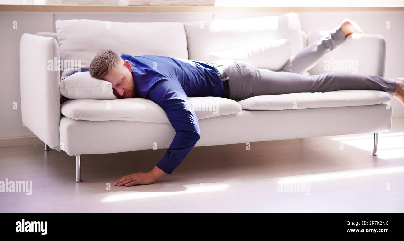 Exhausted Man Falling Asleep On Couch At Home Stock Photo Alamy