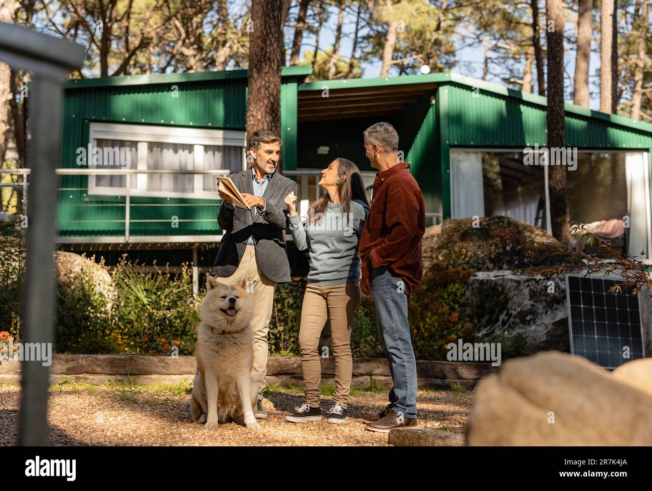 Mature couple with dog visiting property with relator Stock Photo