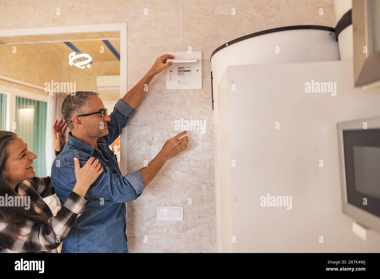 Woman watching man repairing fuse box Stock Photo - Alamy