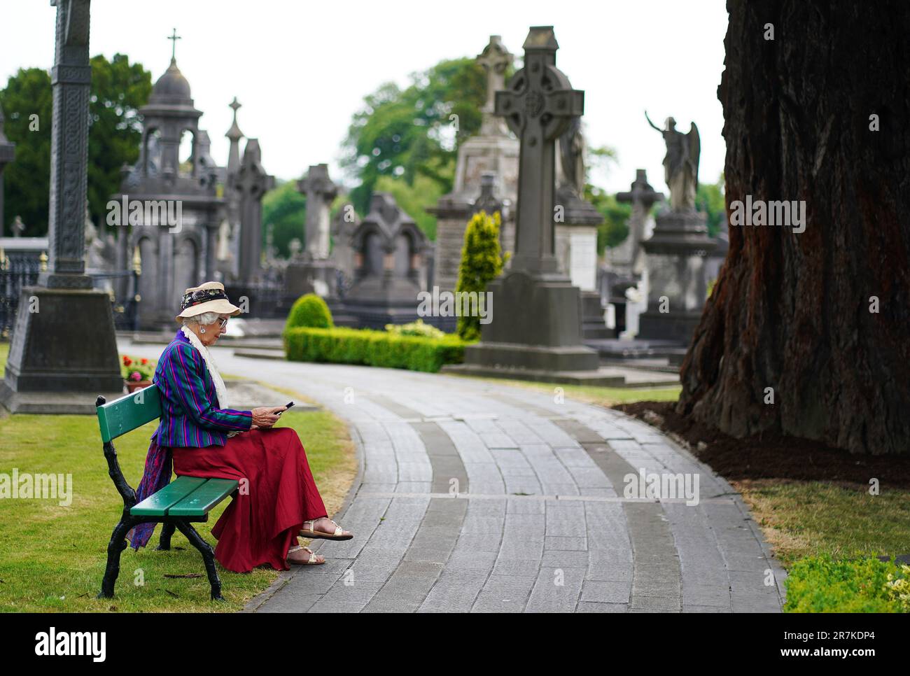 Kitty O'Shea, from Oxford, reads Ulysses on her kindle ahead of the 'Joycestagers' reenactment from the 'Hades' chapter of Ulysses at Glasnevin Cemetery, Dublin, as part of the annual Bloomsday celebrations. Bloomsday is a celebration of the life of Irish writer James Joyce, observed annually worldwide on June 16, the day his 1922 novel Ulysses takes place in 1904, the date of his first outing with his wife-to-be Nora Barnacle. The day is named after its protagonist Leopold Bloom. Picture date: Friday June 16, 2023. Stock Photo