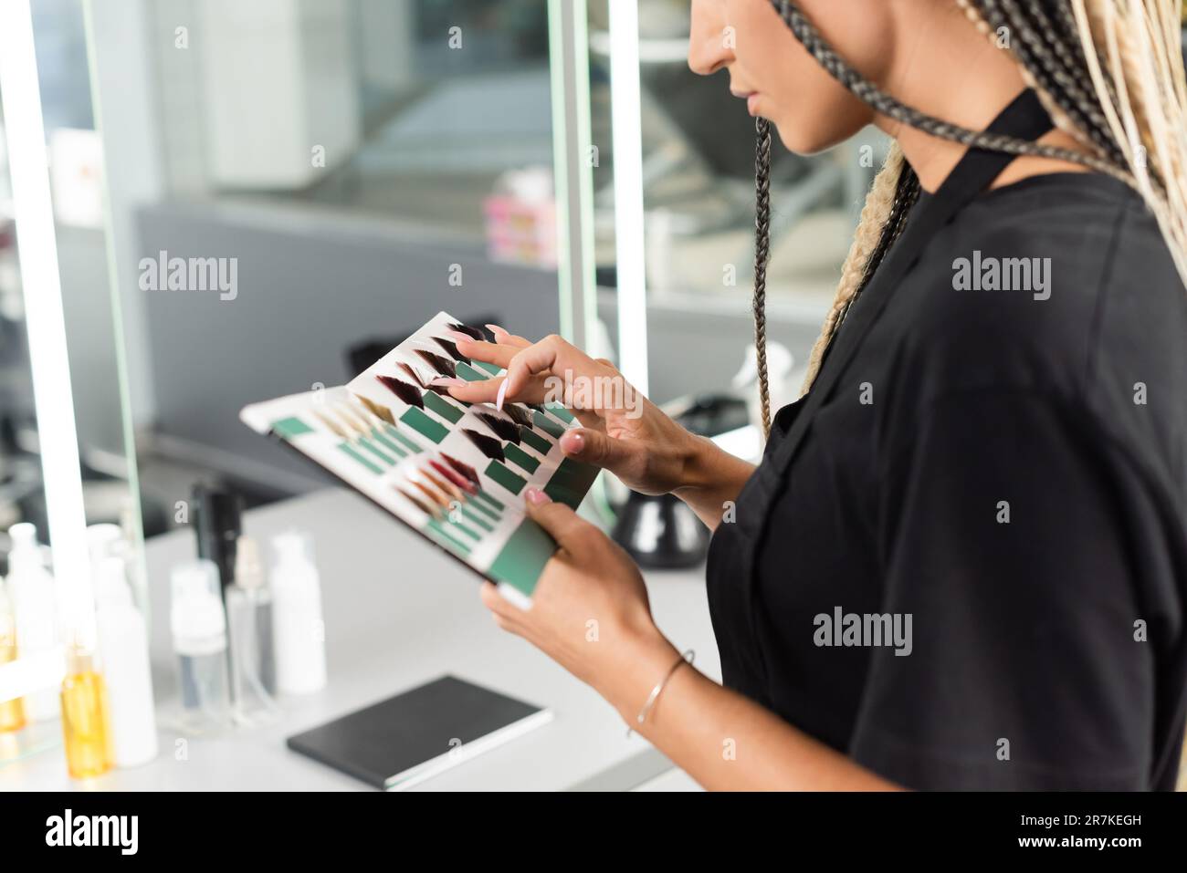 hair professional, cropped view of beauty worker with braids holding hair color palette in beauty salon, hair extension, hair stylist, salon job, beau Stock Photo