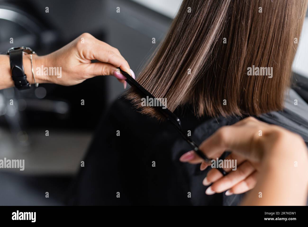 close up of hairdresser cutting short brunette hair of female client, beauty worker, haircut, salon job, beauty industry, scissors and professional co Stock Photo