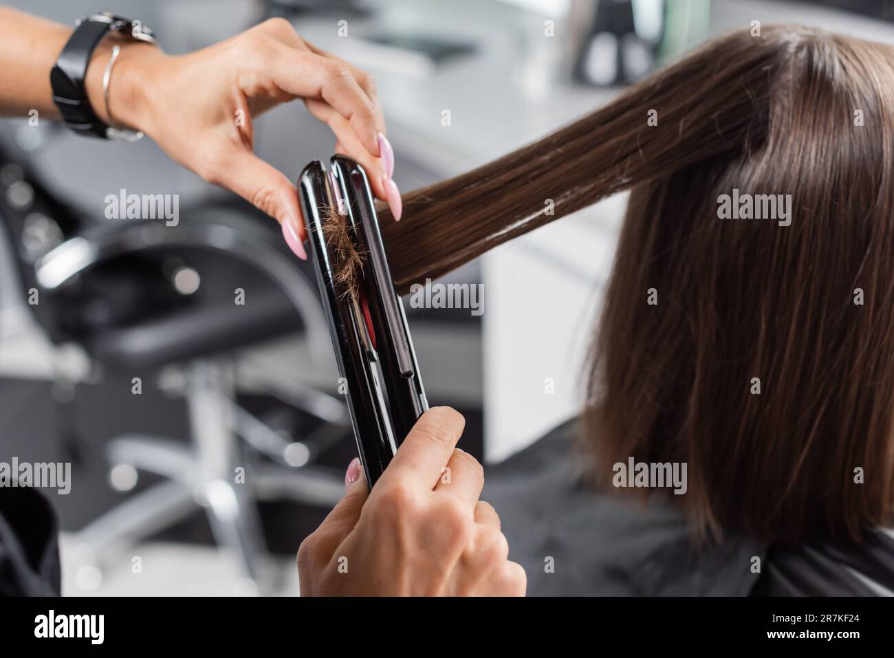 hair ironing, professional hairdresser with hair straightener styling