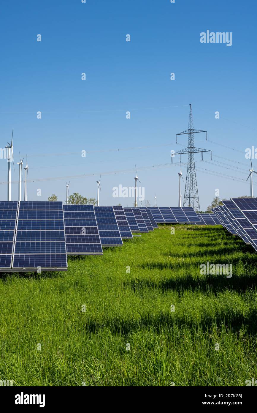 Solar energy plant with power lines and wind turbines in the back seen