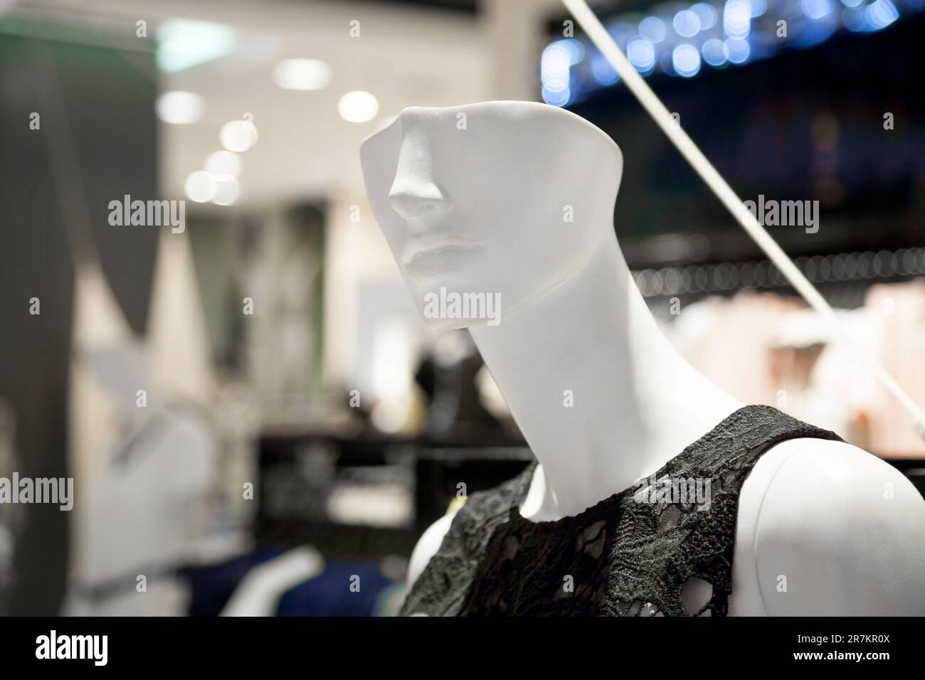 White lady mannequin wearing a black summer blouse in a fashion boutique. Unusual half-headed female dummy demonstrating summer clothes in a shopping - Stock Image