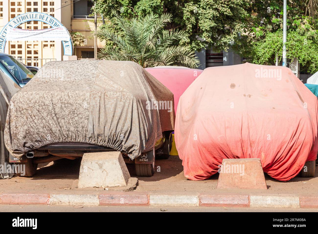 Two covered cars on a street in Bamako, Mali, to protect them from dust and heat. Stock Photo
