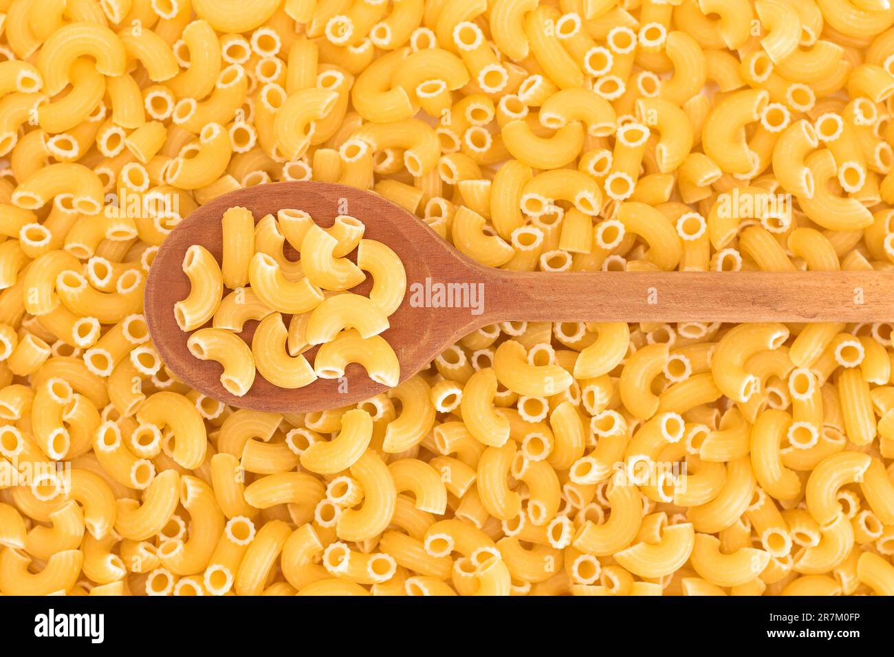 Uncooked Chifferi Rigati Pasta Background with Wooden Spoon. Fat and ...