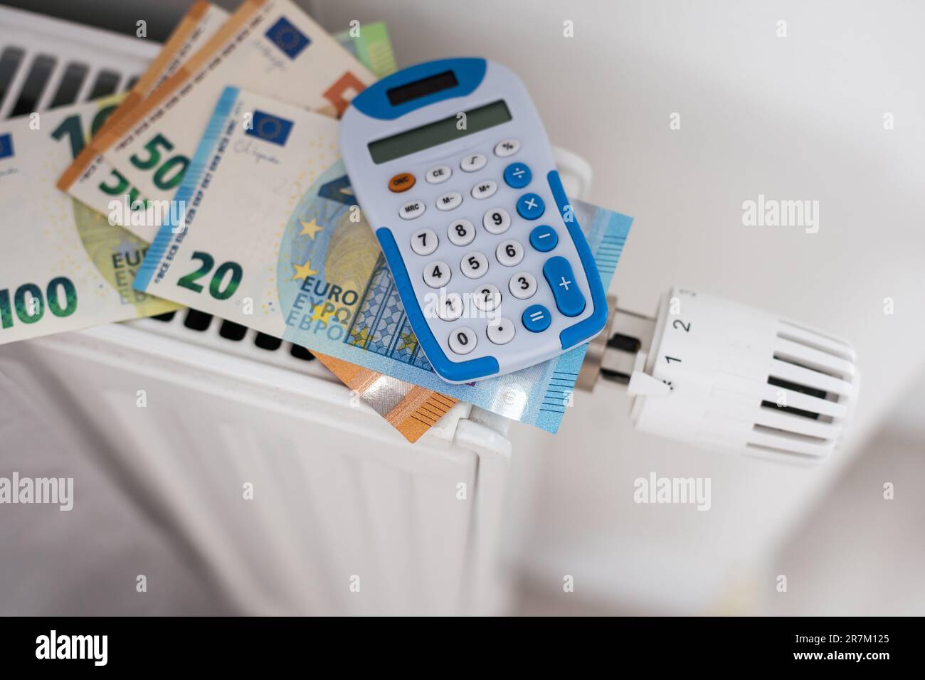 New thermostat with Euro cash on a radiator heating at home. Expensive