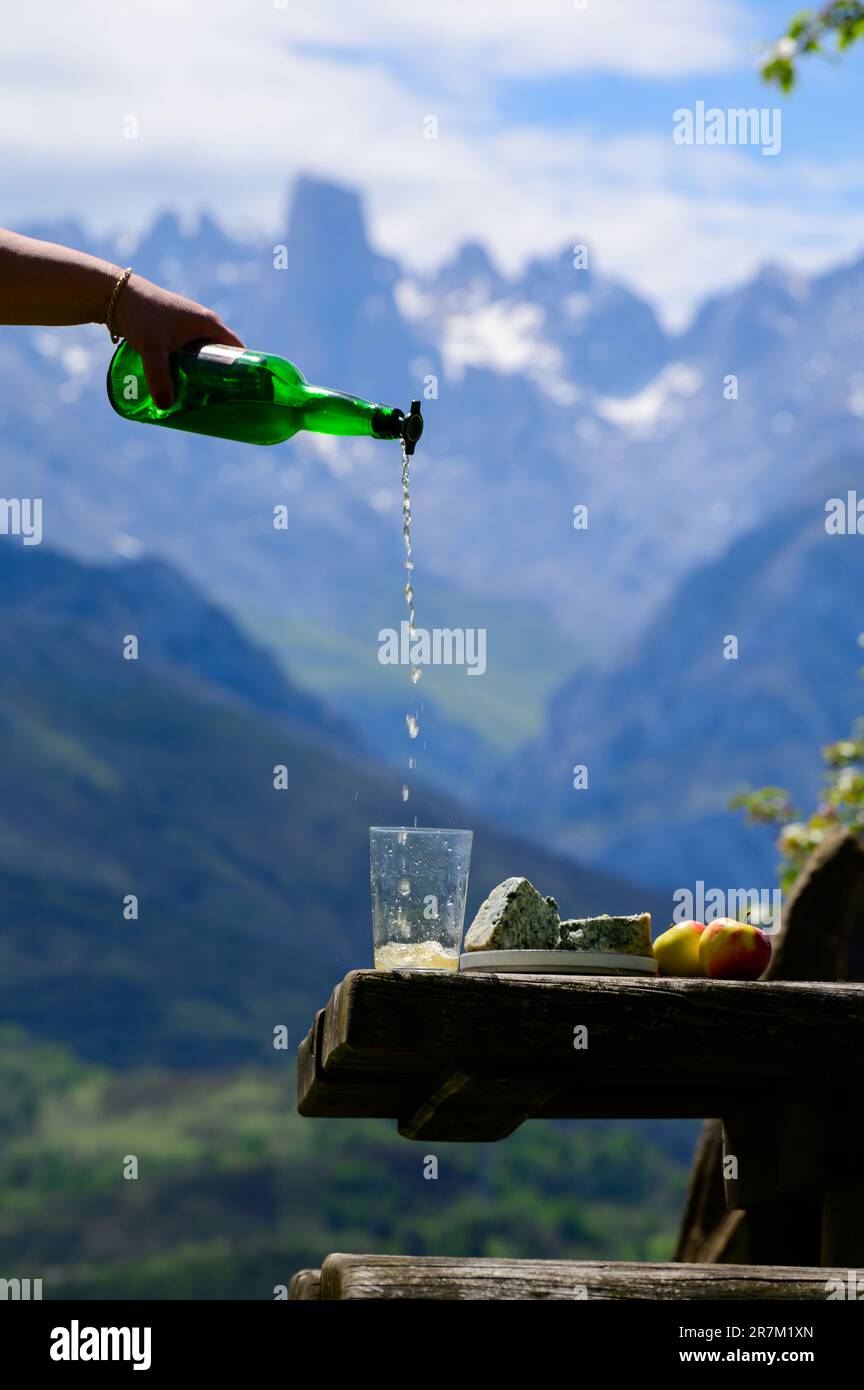 Pouring from high height of natural Asturian cider made from fermented