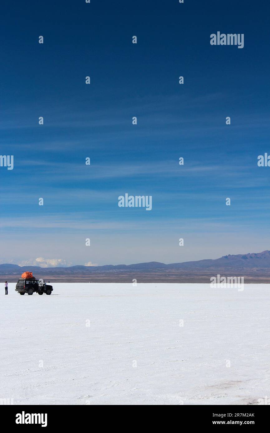 Red jeep in the middle of the Salar de Uyuni, Bolivian highlands Stock Photo