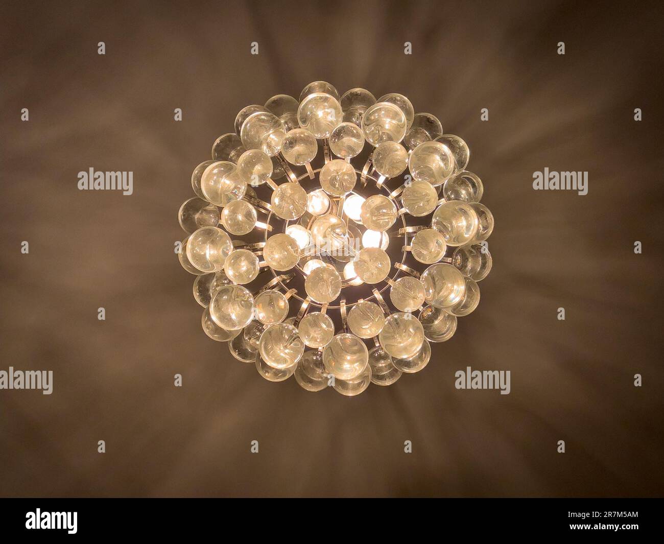 View of a light and shadowy motif on a ceiling created by a bubble glass chandelier. Stock Photo