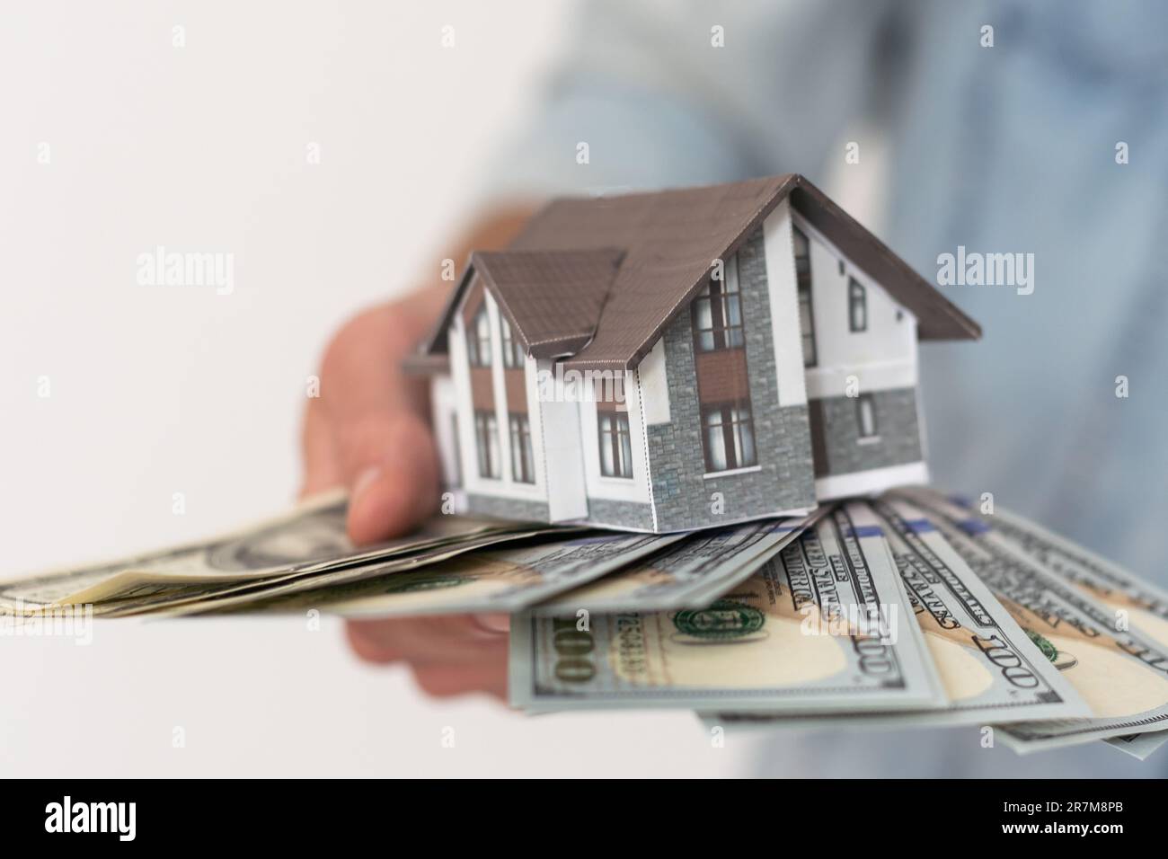 Real estate agent holding house model Stock Photo - Alamy