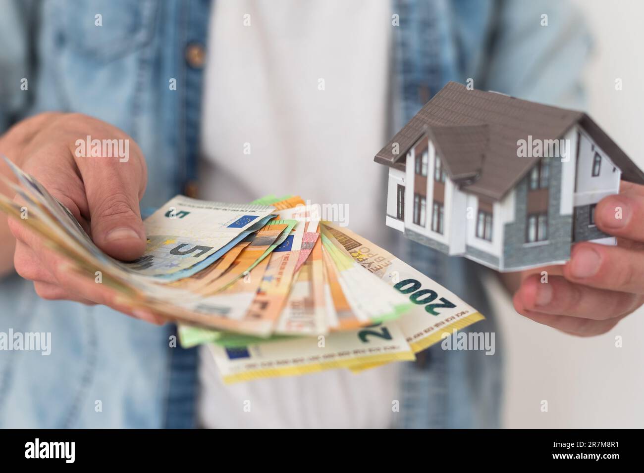 Real estate agent holding house model Stock Photo - Alamy