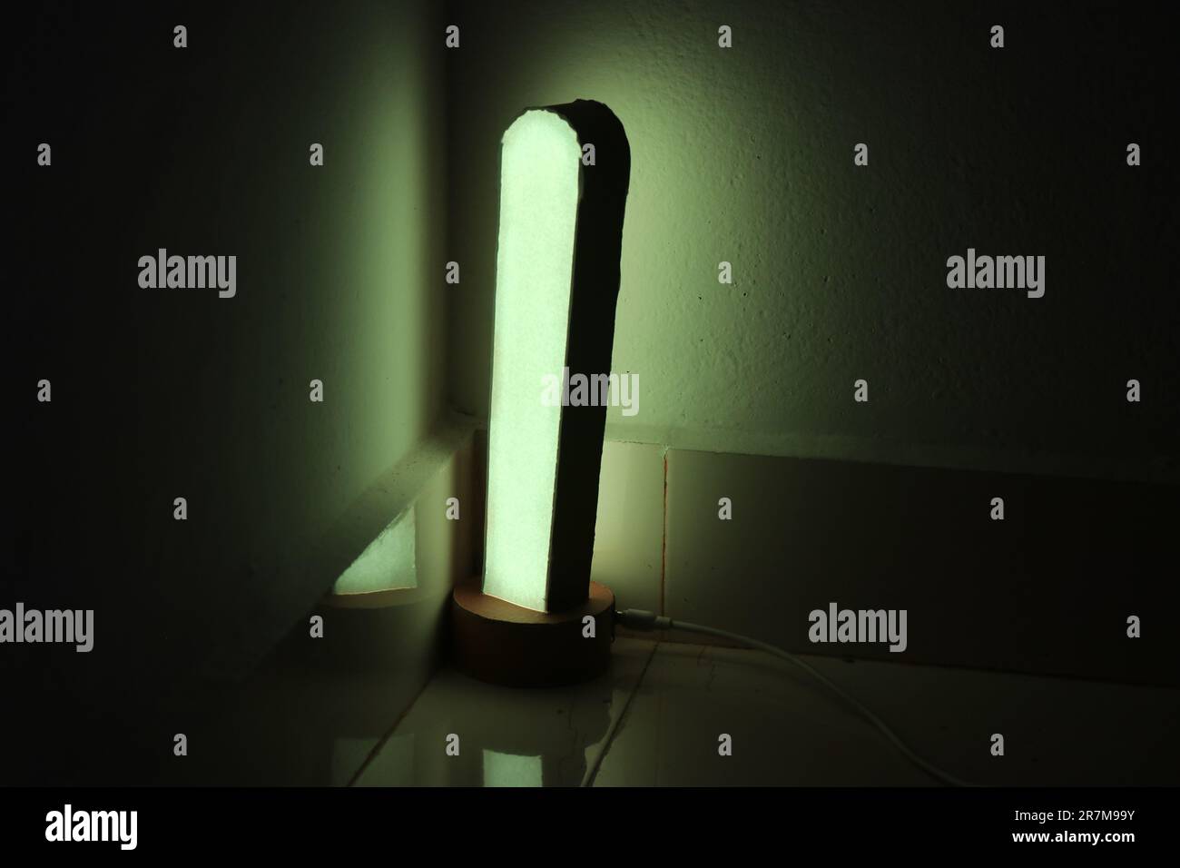 Modern desk lamp with green color light reflections on a wall Stock Photo