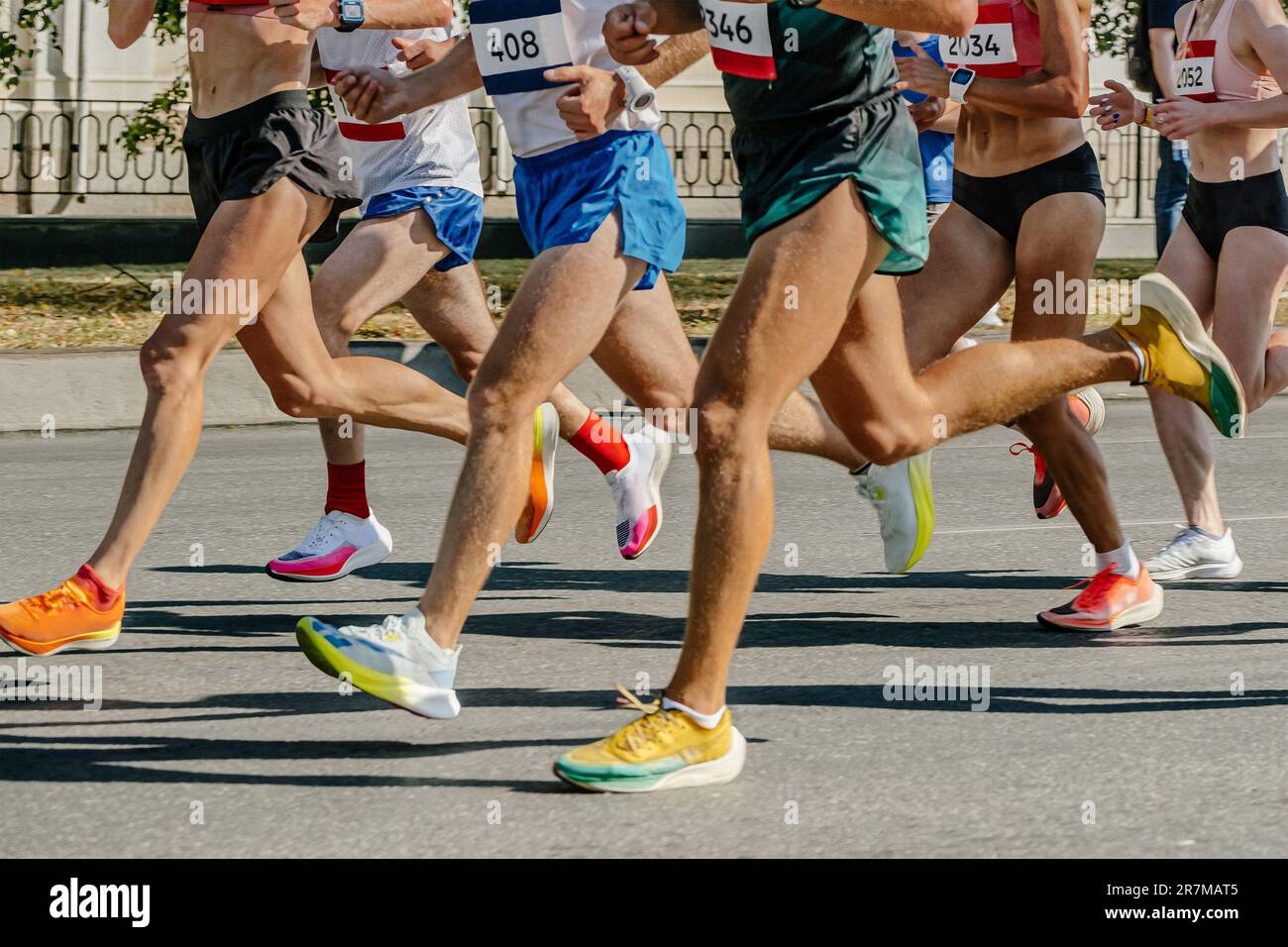 legs runners athletes women and men running city marathon, group sportive joggers run together Stock Photo