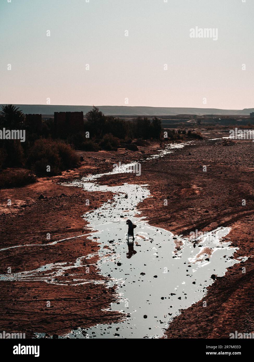 River crossing: A woman strides across a dry riverbed, embodying