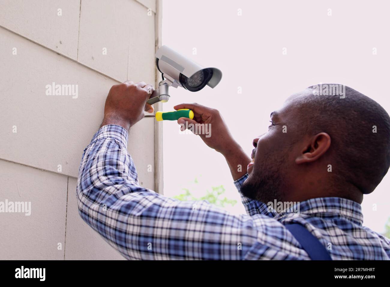 African American Handyman With CCTV Camera, Security System Stock Photo