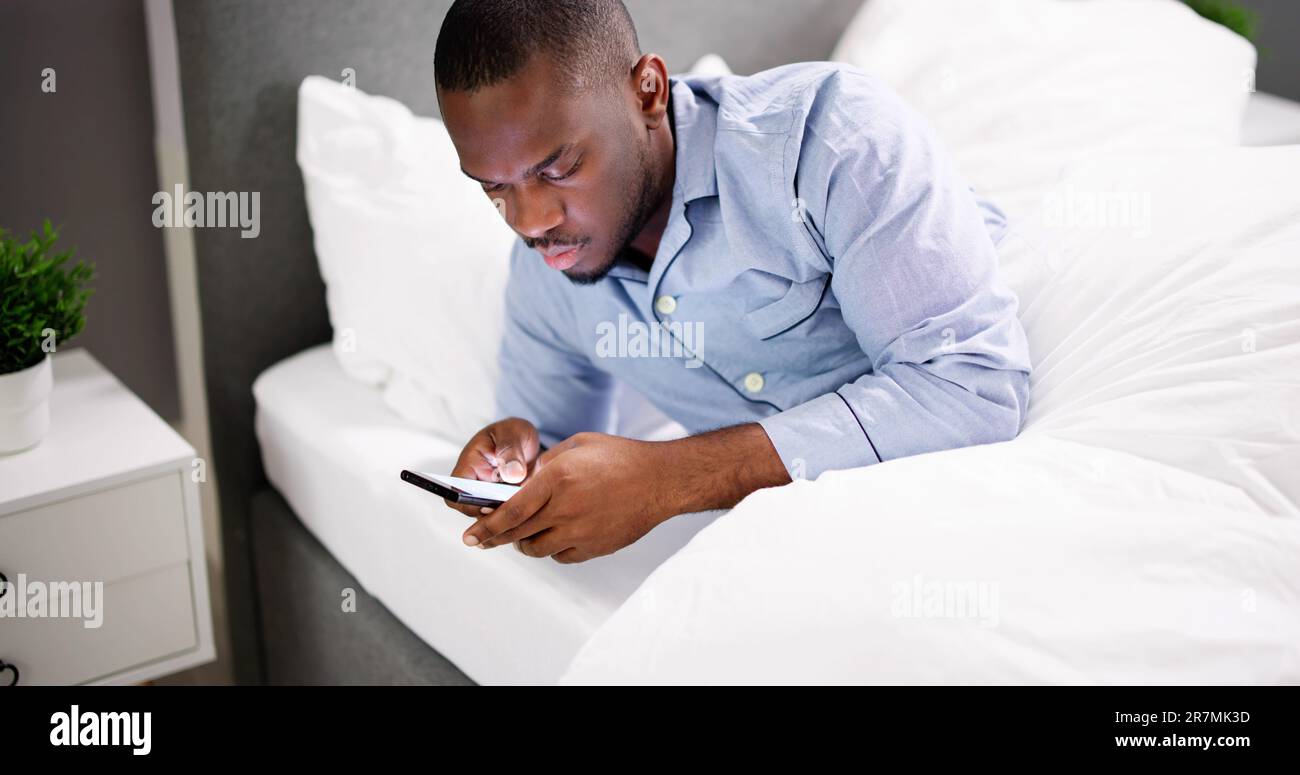 African Man Holding Smartphone Or Mobile Phone Stock Photo