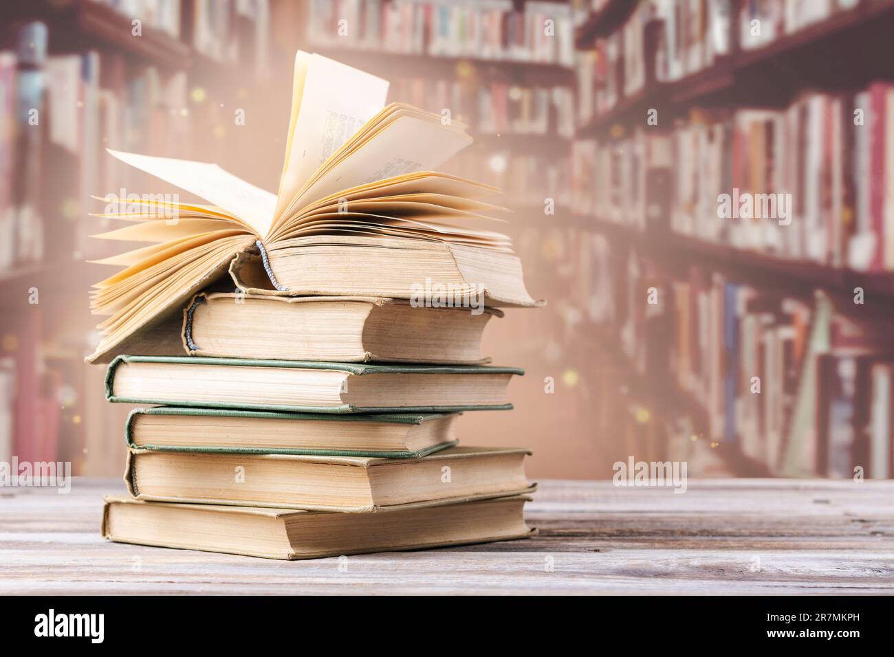 Book with opened pages and stacked books on reading desk in library ...