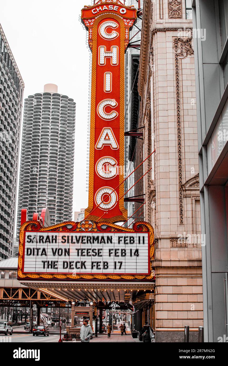 A vibrant, iconic Chicago skyline sign with a view of a theater in the ...