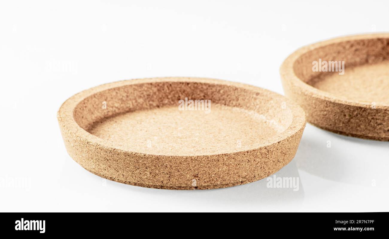Two cork wood saucers close-up on a white background with shadows Stock Photo
