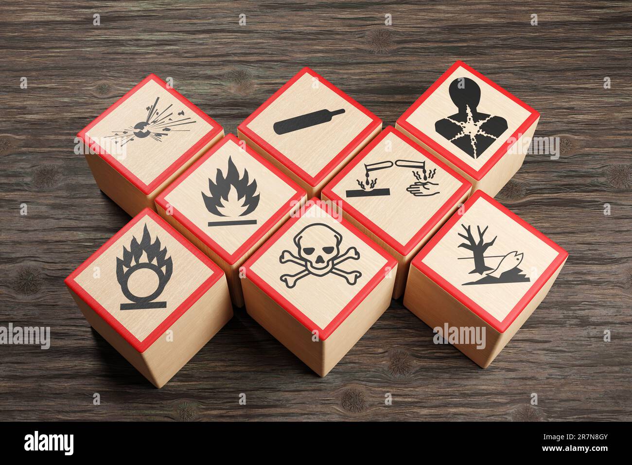 Wooden blocks showing different symbols of chemical hazard warnings on wood table. Concept of toxic substances and occupational health Stock Photo