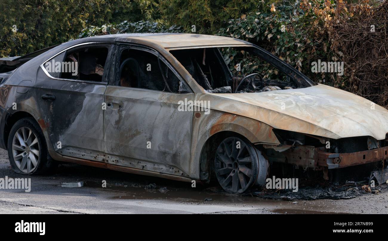 Burnt car wreckage, destroyed by arsonists. Vandalism. Stock Photo