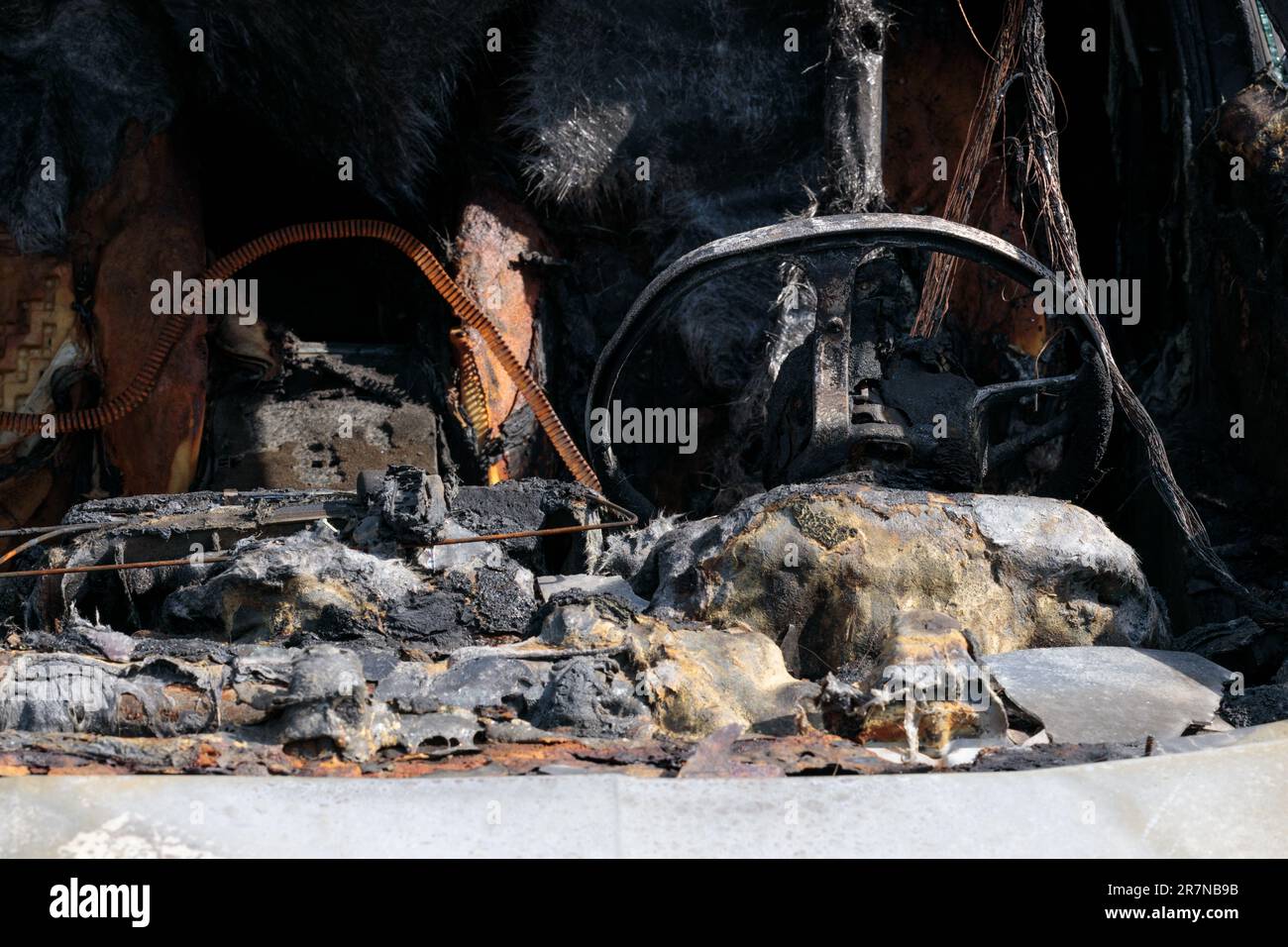 Burnt car wreckage, destroyed by arsonists. Close--up Stock Photo