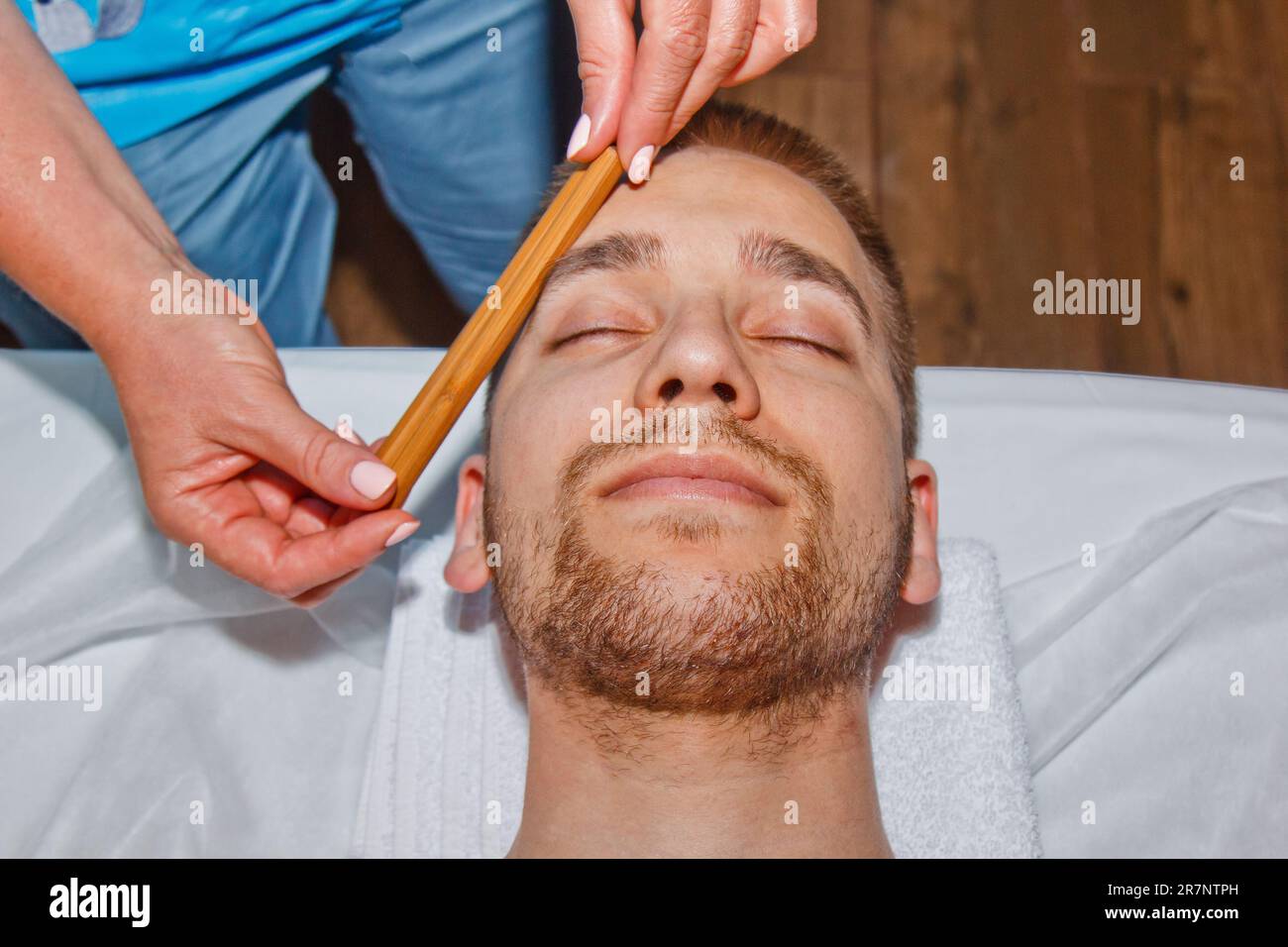 Wellness concept. Professional masseur gives a man a Thai facial