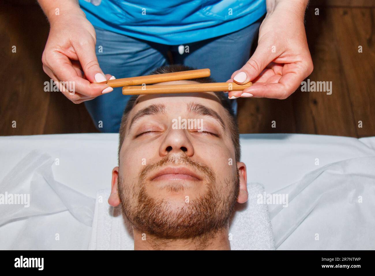 Wellness concept. Professional masseur gives a man a Thai facial