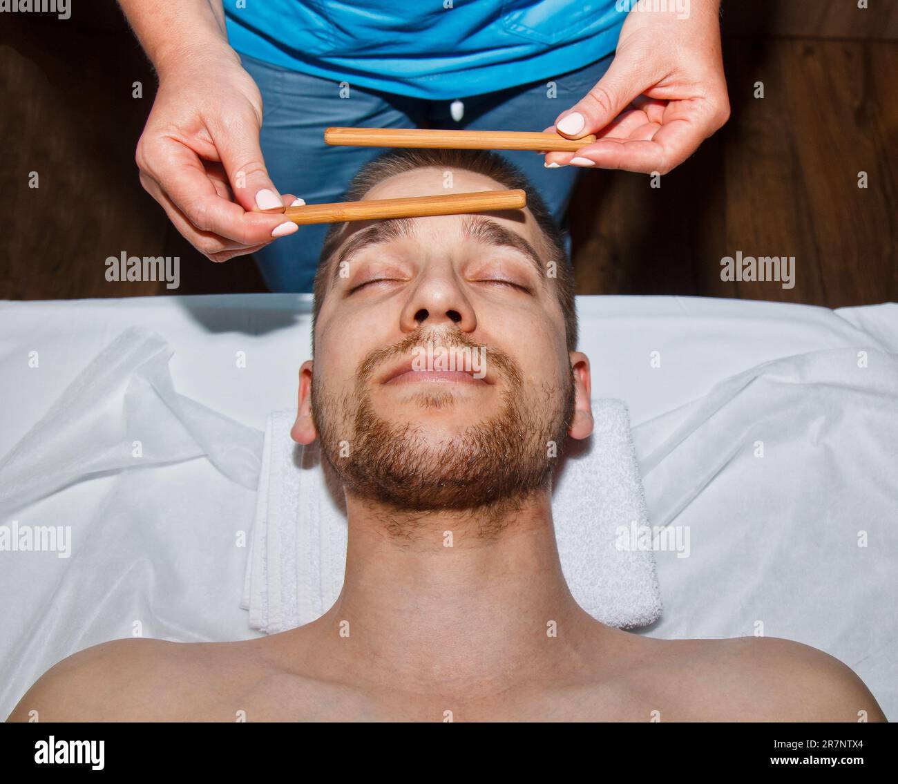 Wellness concept. Professional masseur gives a man a Thai facial