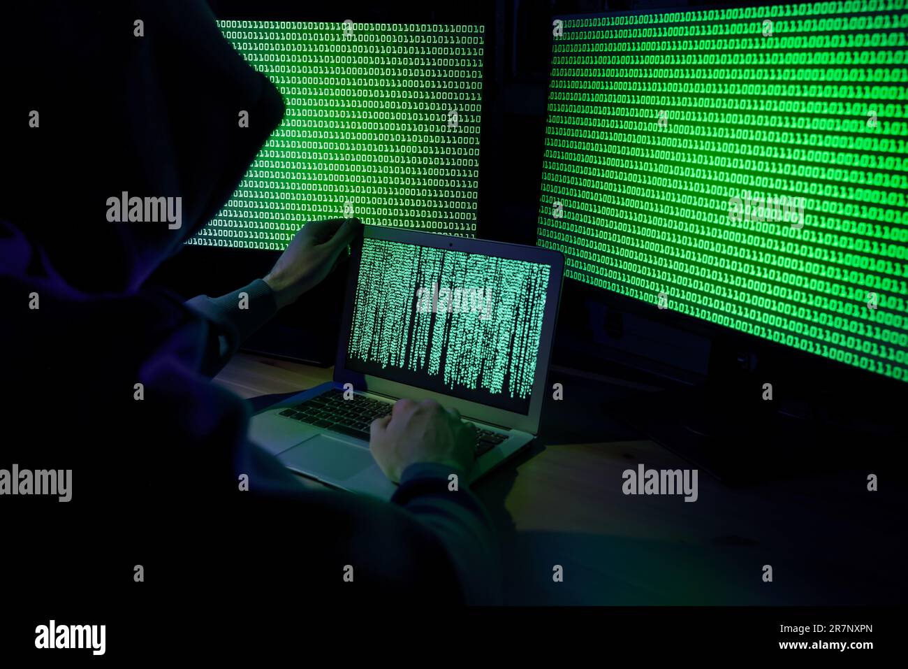 Hacker working with computers at wooden table indoors. Cyber attack Stock Photo
