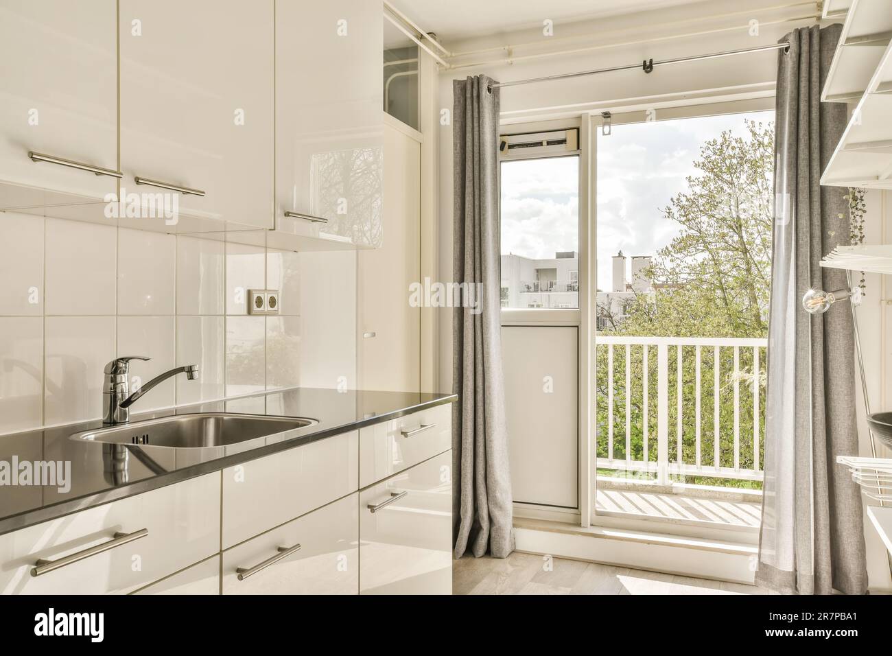 a kitchen area with white cabinets and black counter tops in front of ...