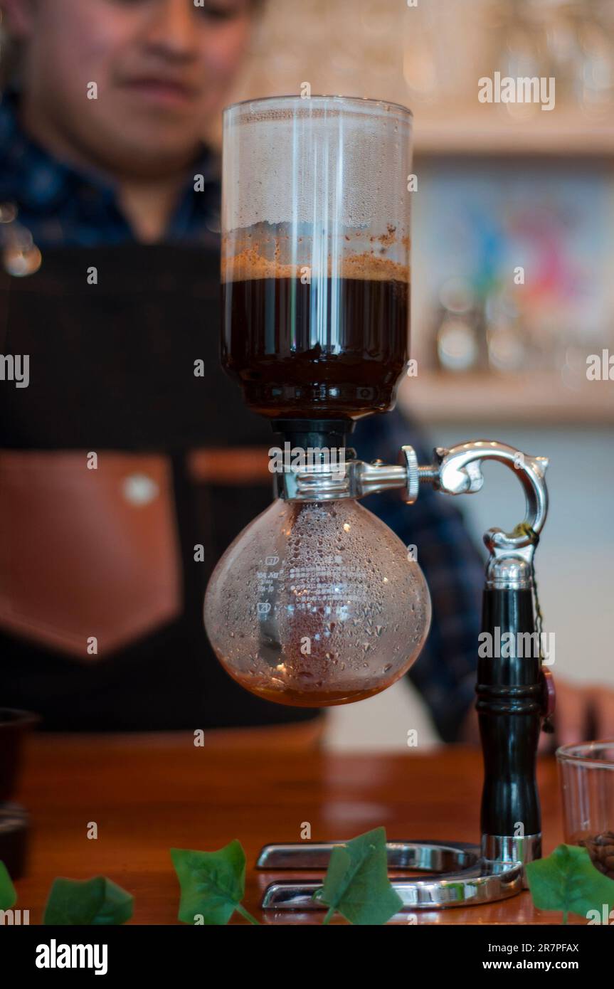 closeup of a japanese coffee maker with espresso coffee, behind a
