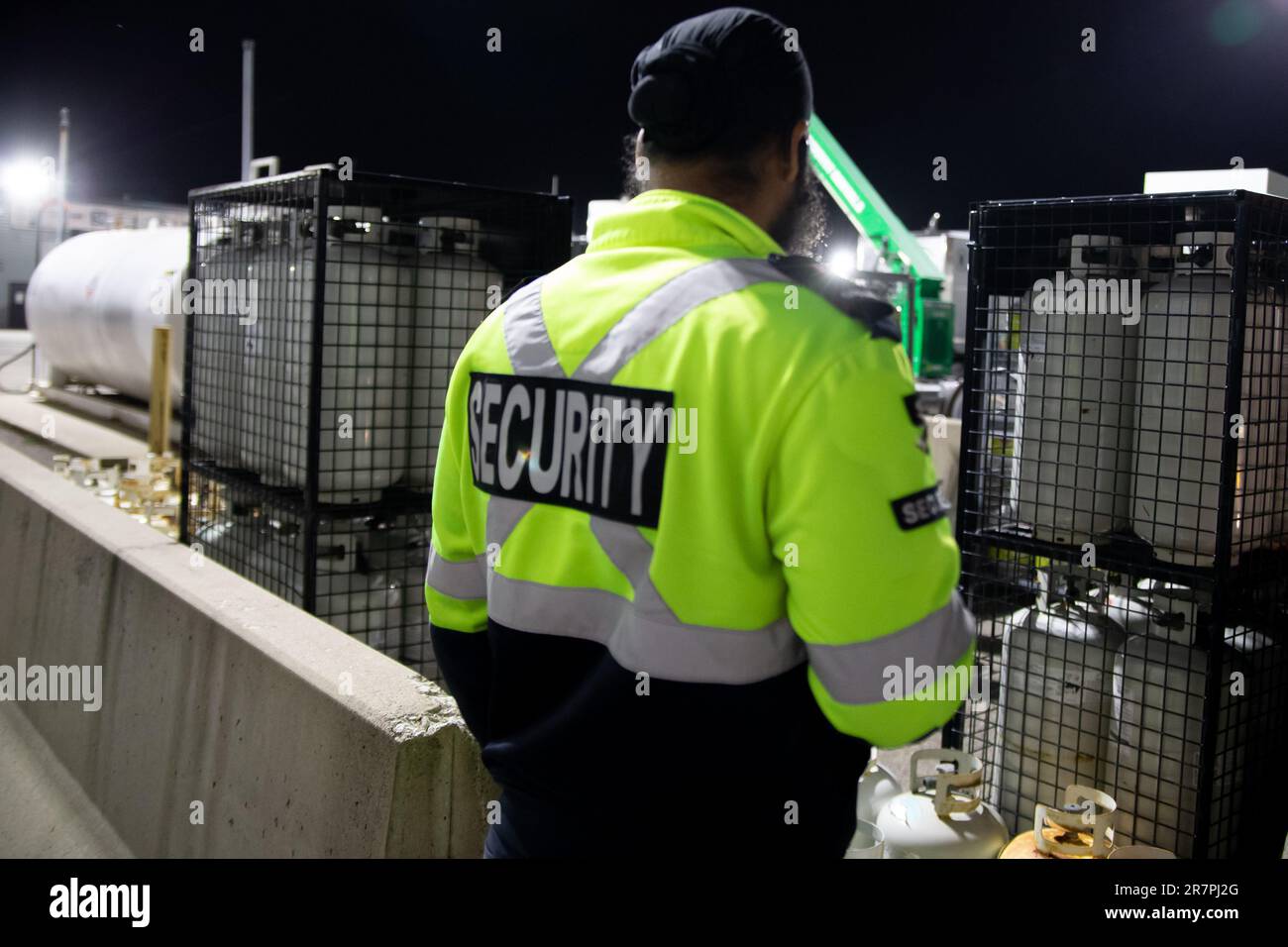 Security guard patrolling commercial storage area at night Stock Photo