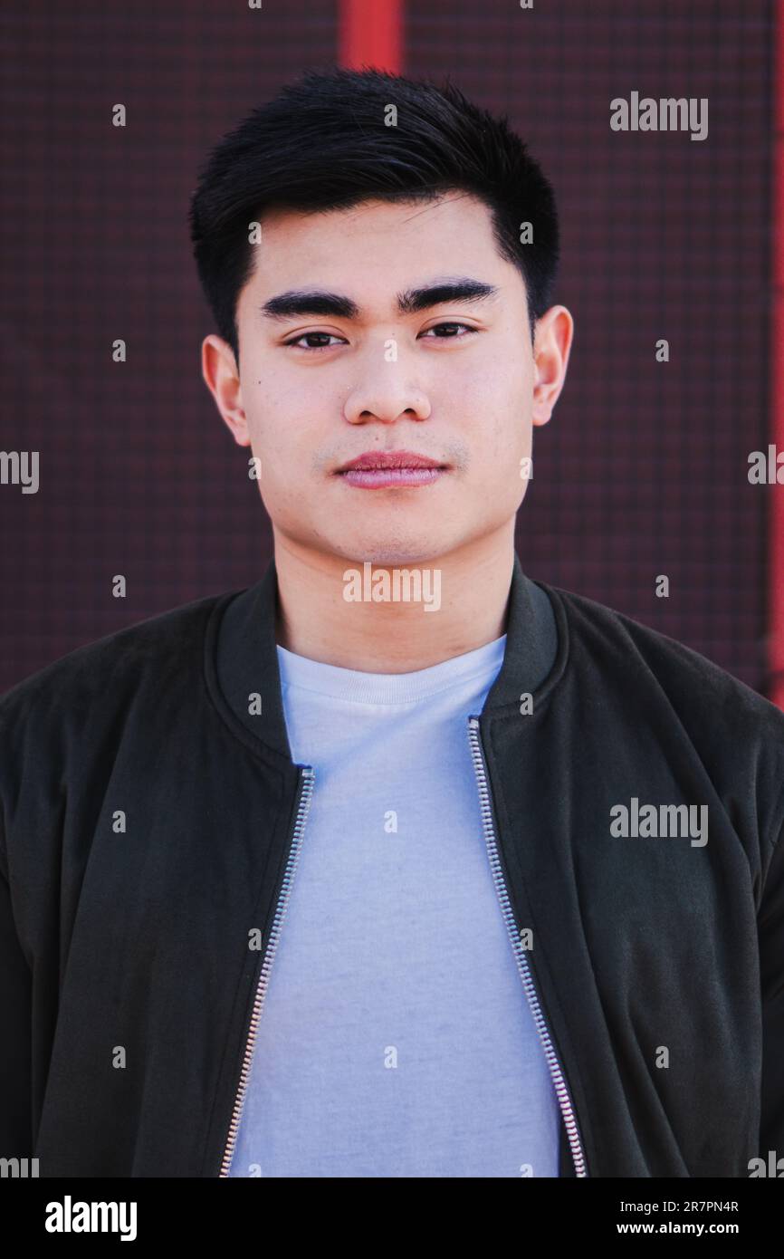 Vertical portrait of handsome serious chinese male school student dressed in casual clothes, looking pensive at camera with confident and thougthful expression on his face. Front view of a asian guy. High quality photo Stock Photo