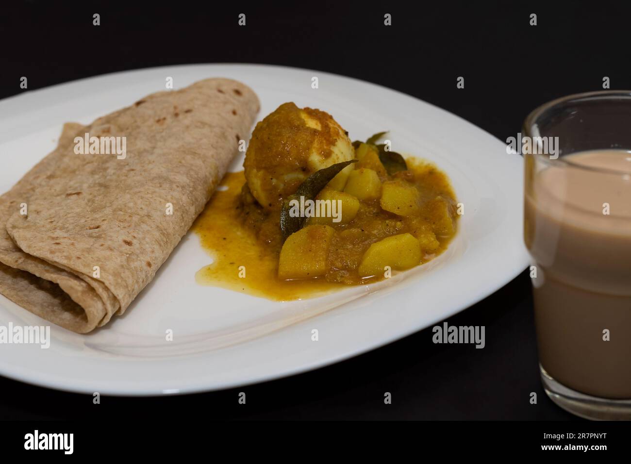 North Indian Style Breakfast. Chappathi And Egg Curry In Isolated Black Background Stock Photo