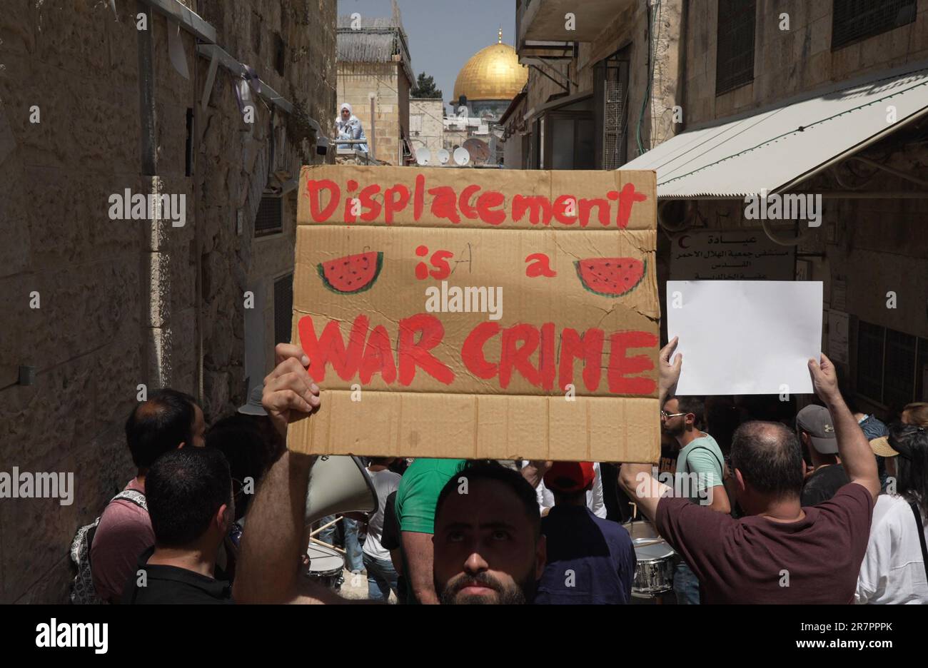 JERUSALEM, ISRAEL - JUNE 16: A protestor holds a sign which reads 'Displacement is a war crime' during a demonstration held by Palestinians and Israeli peace activists against the eviction of Palestinian Sub-Laban family from their home in front of their house in the old city on June 16, 2023 in Jerusalem, Israel. After decades of legal wrangling, the Sub Laban family lost their case in the Israeli courts against Jewish organizations to take over their home in the Muslim Quarter of Jerusalem. Credit: Eddie Gerald/Alamy Live News Stock Photo