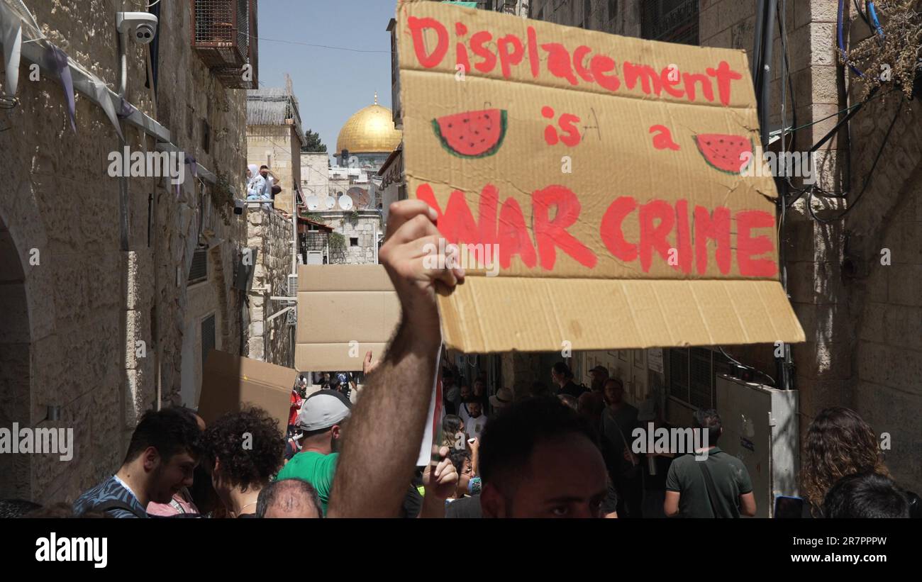 JERUSALEM, ISRAEL - JUNE 16: A protestor holds a sign which reads 'Displacement is a war crime' during a demonstration held by Palestinians and Israeli peace activists against the eviction of Palestinian Sub-Laban family from their home in front of their house in the old city on June 16, 2023 in Jerusalem, Israel. After decades of legal wrangling, the Sub Laban family lost their case in the Israeli courts against Jewish organizations to take over their home in the Muslim Quarter of Jerusalem. Credit: Eddie Gerald/Alamy Live News Stock Photo