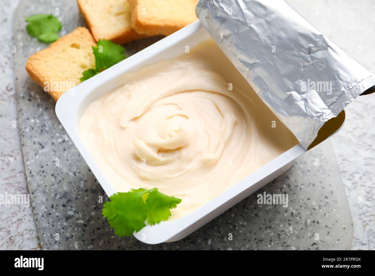 https://c8.alamy.com/comp/2R7PRGX/plastic-container-with-tasty-cream-cheese-on-table-2R7PRGX.jpg