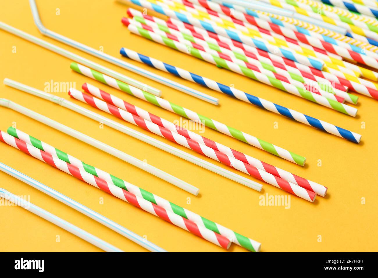 Different drinking straws on orange background Stock Photo