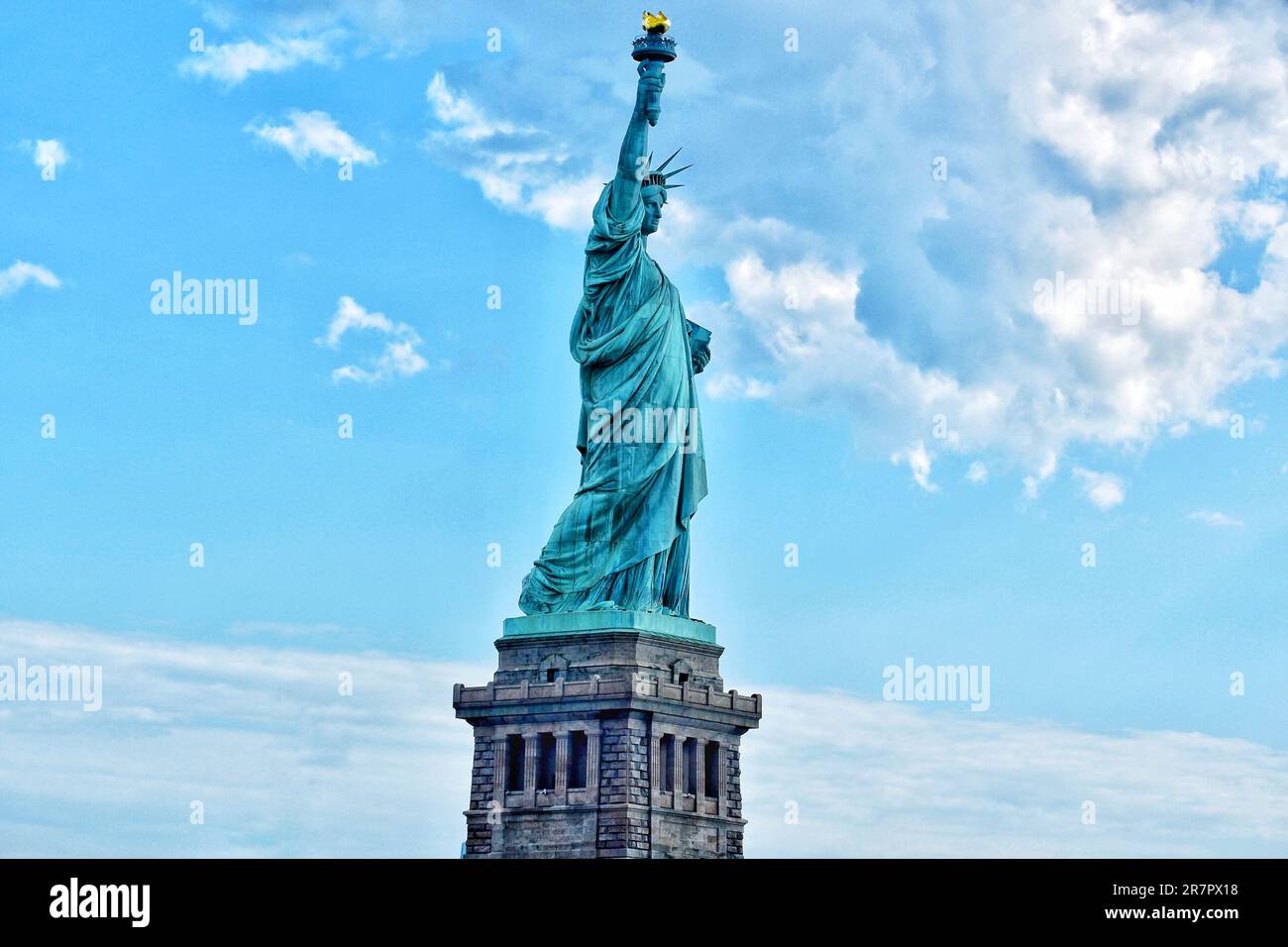 The iconic Statue of Liberty stands prominently against a backdrop of