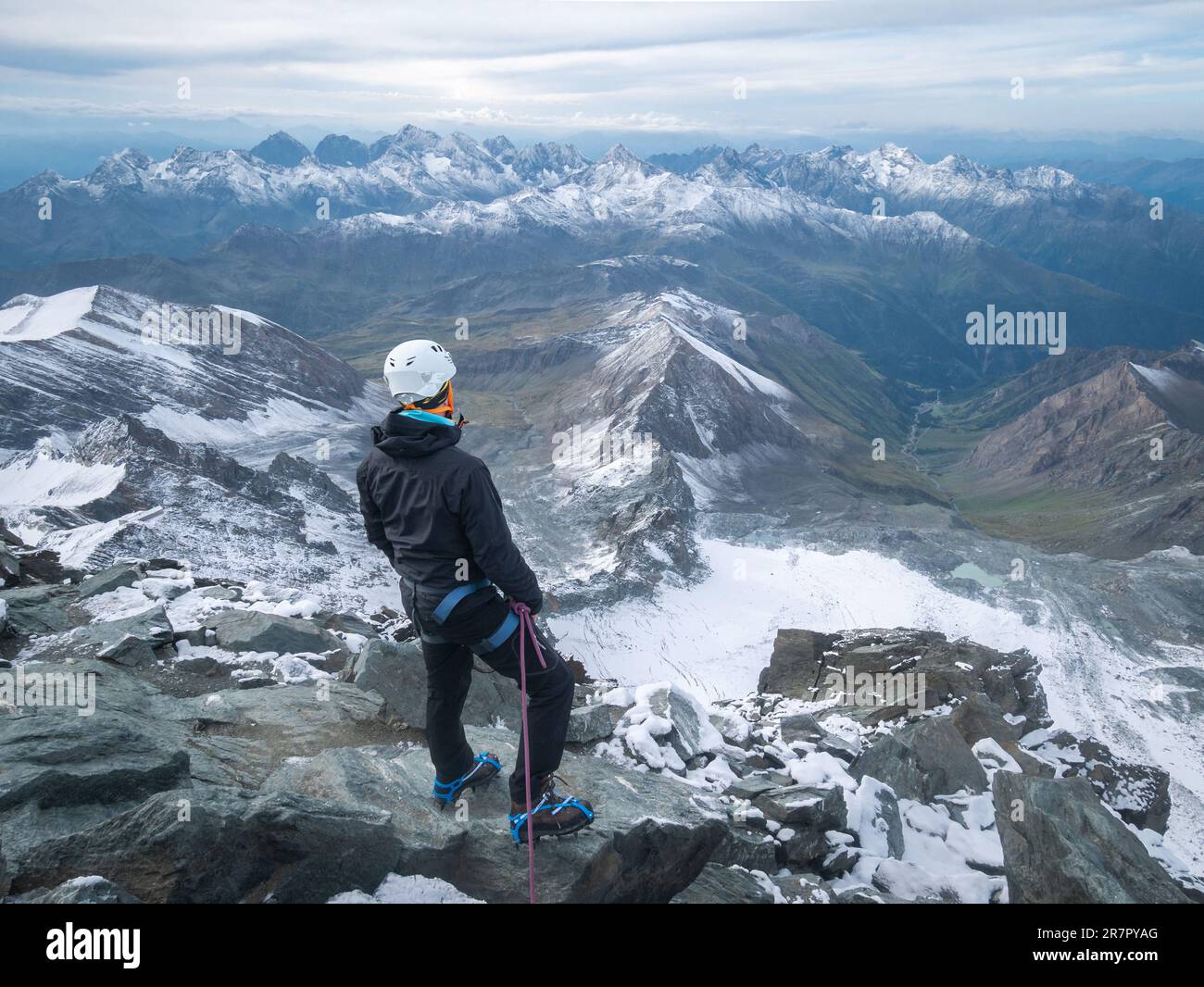 Mountaineer enjoying views on alpine landscape after reaching peak summit, Austrian Alps, Europe Stock Photo