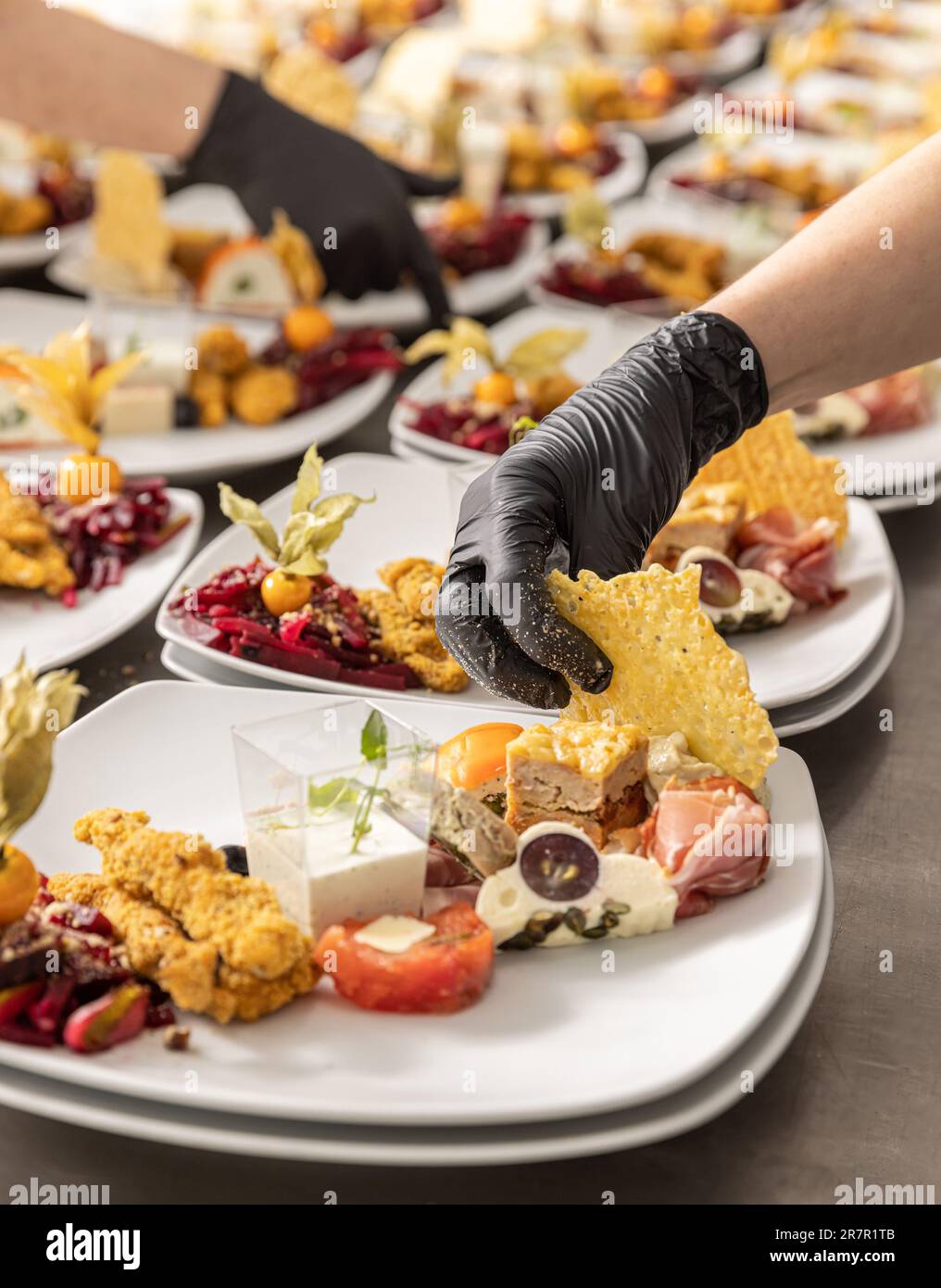 Chef is garnishing delicious appetizer dishes in restaurant kitchen