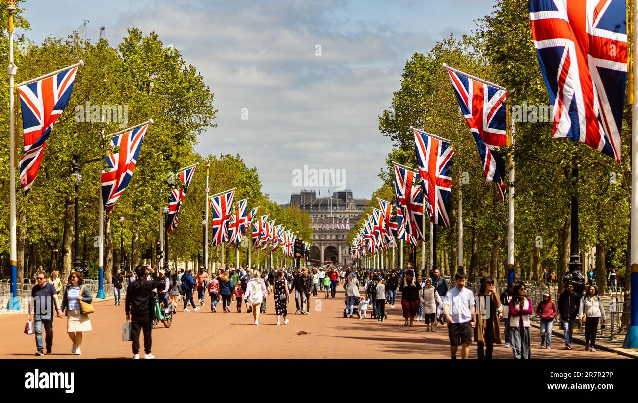 London, 29th May 2023: Pedestrians are walking along the Mall, Union Jack Flags on both sides along the road, Admiralty Arch in the background. Stock Photo