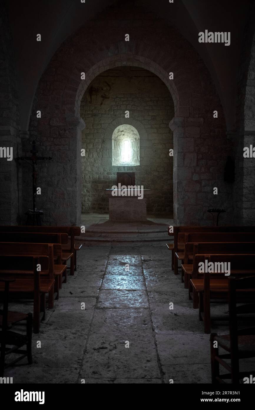 Dark interior lit with one window only of Saint-Jean le Froid chapel near Cahors, Southwest France. Stock Photo