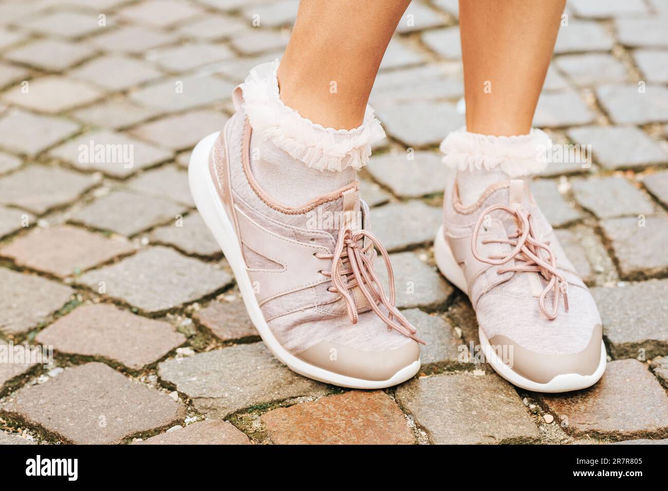 Woman wearing new comfy trainers and soft pink ruffle socks, close up image Stock Photo